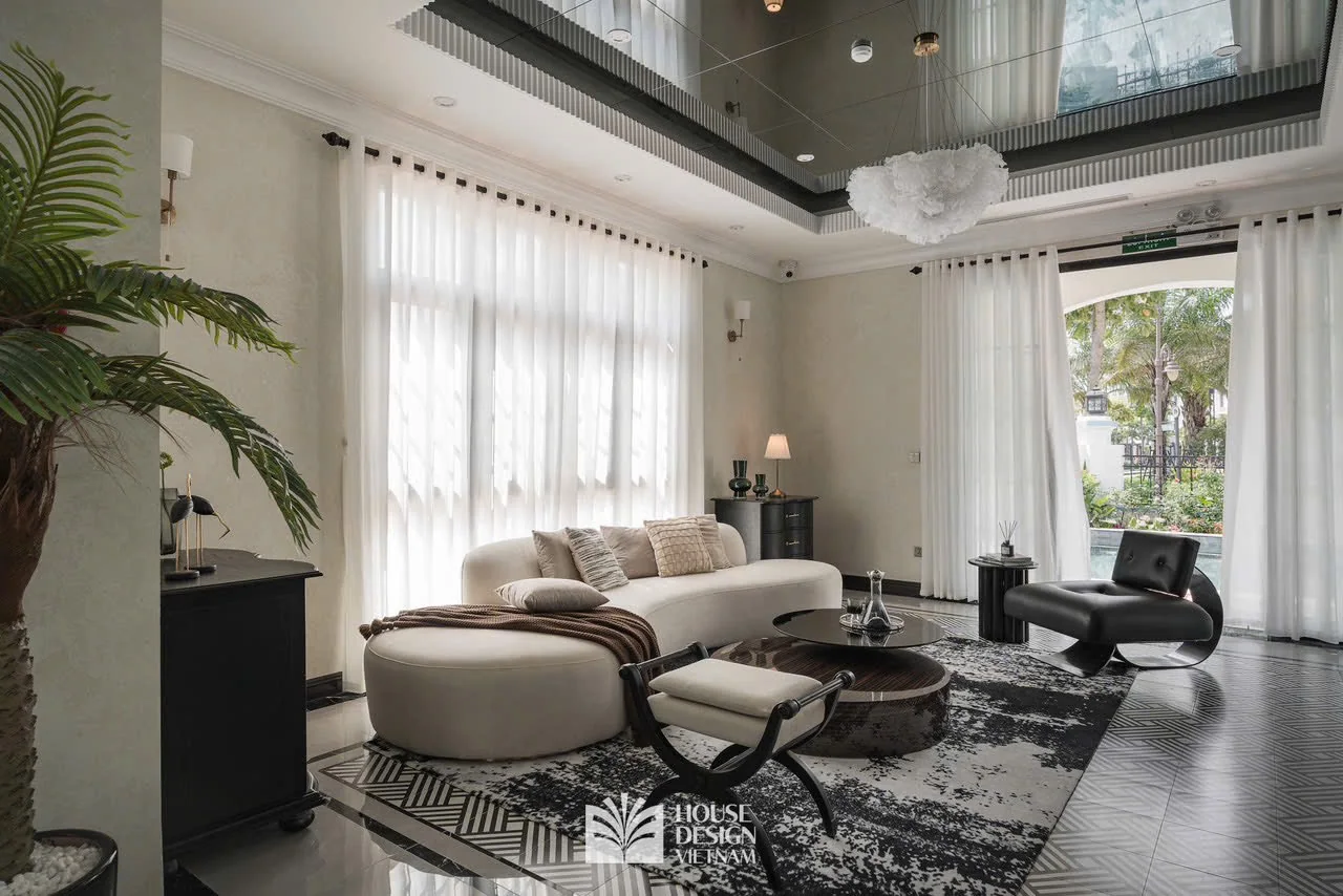 Không gian phòng khách với sofa sáng màu và cửa kính lớn