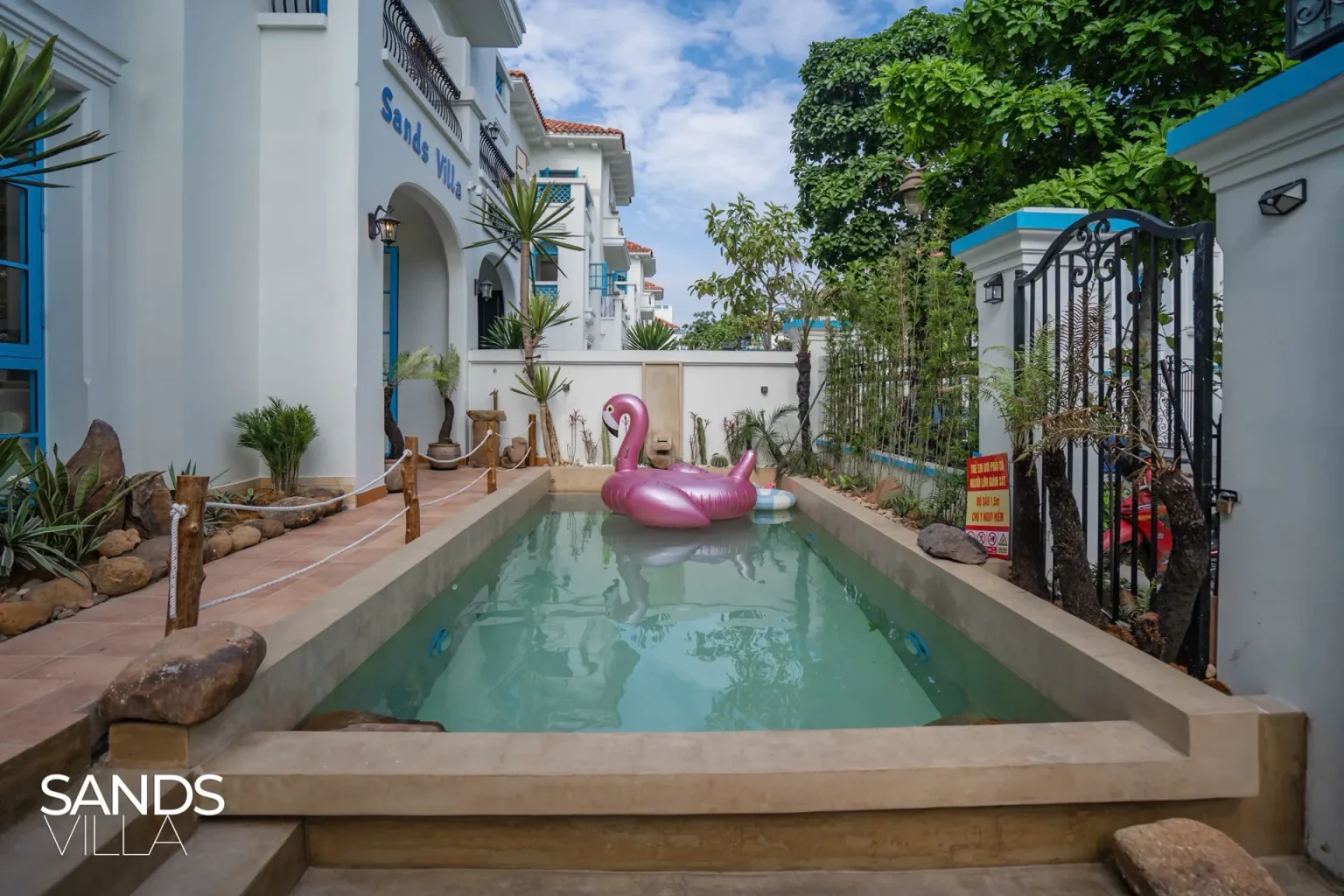 Hồ bơi riêng ngoài trời Sands Villa C6-16 ban ngày với phao hồng hạc
