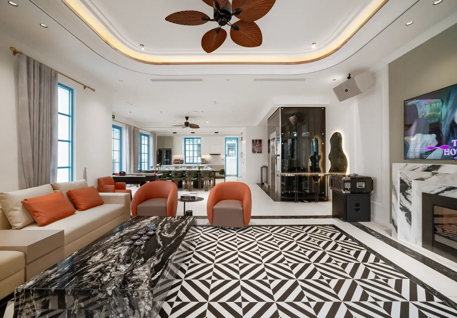 Phòng khách Fancy De Villa với sofa sáng màu, ghế cam và thảm họa tiết