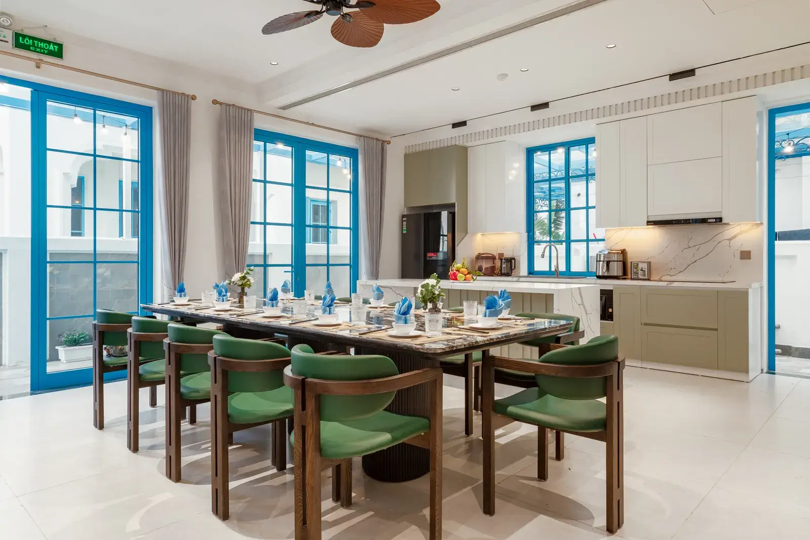 Bếp liền bàn ăn dài với ghế xanh trong Fancy De Villa