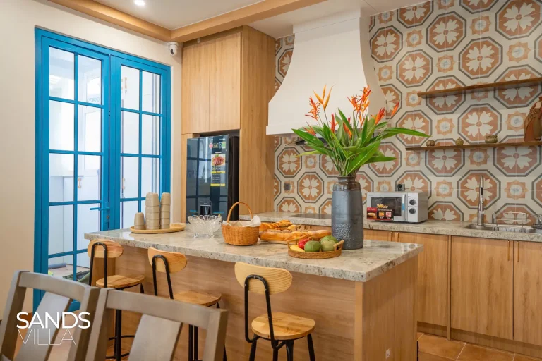 Đảo bếp đá granite, tủ lạnh và lò vi sóng trong bếp Sands Villa C6-16