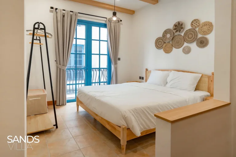 Phòng ngủ giường đôi Sands Villa C6-16 với cửa kính xanh ra ban công