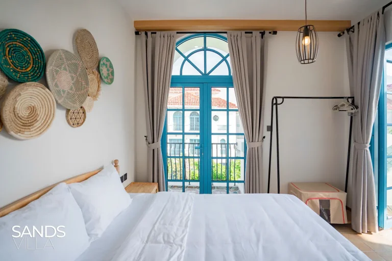 Phòng ngủ Sands Villa C6-16 có cửa vòm khung xanh và đĩa mây trang trí