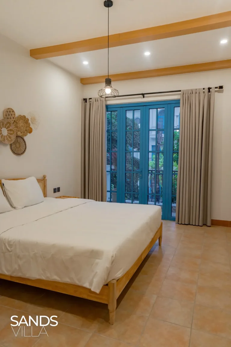Phòng ngủ Sands Villa C6-16 có cửa kính lớn nhìn ra cây xanh