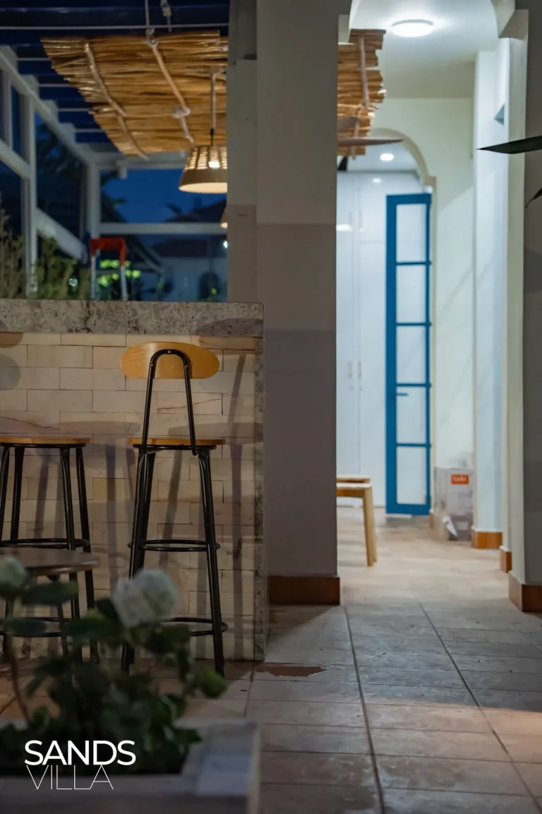 Quầy bar ngoài trời Sands Villa C6-16 buổi tối với ghế cao gỗ