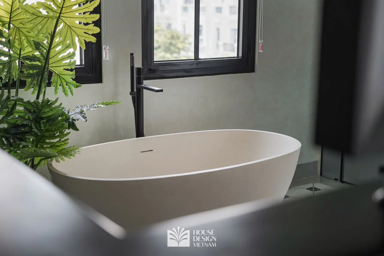 Bồn tắm độc lập bên khung cửa sổ phòng tắm villa